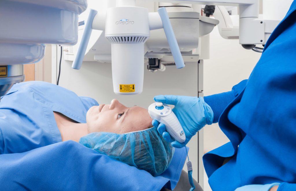 female patient undergoing corneal cross-linking looking upwards into machine