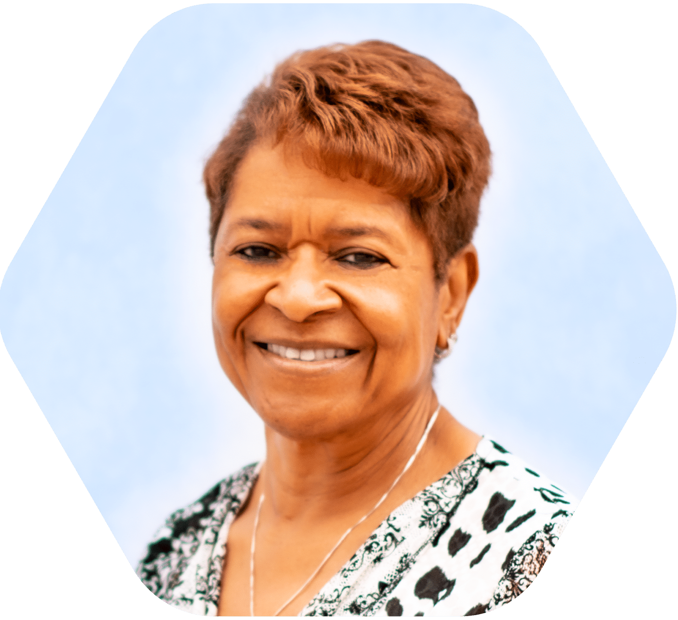 close up headshot of middle aged woman smiling with short hair and light blue and white background