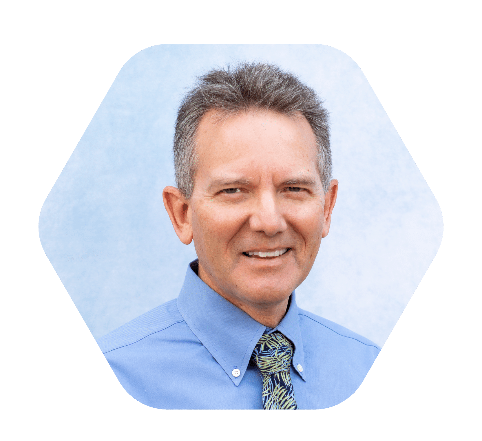 close up headshot of middle aged man smiling with blue dress shirt and tie against light blue and white background
