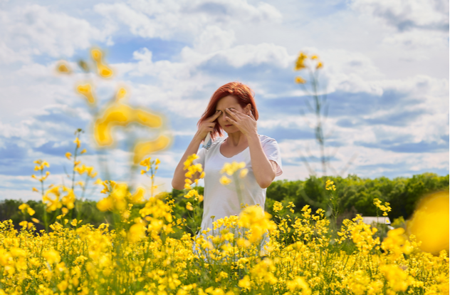 Girl cries and rubs her eyes due to allergy to pollen