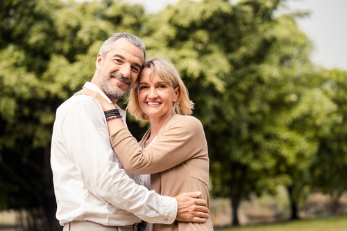 Wife hugging husband from behind and smile with happiness.