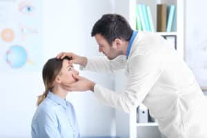 Eye doctor examining patient’s eyes during a vision consultation, evaluating LASIK or EVO ICL candidacy