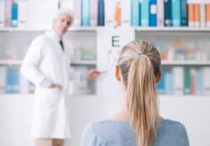 Patient undergoing a vision test during an eye exam, part of the diagnostic process for detecting astigmatism