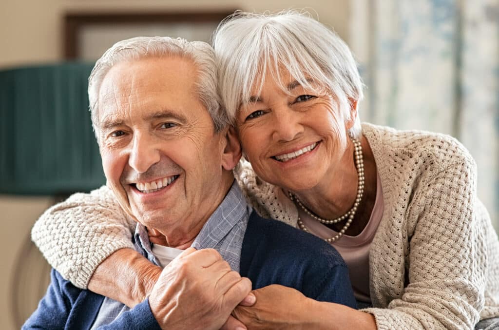Happy senior couple embracing at home with love